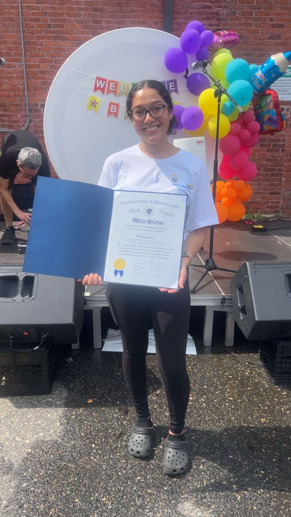 A GEMS youth leader holding her State Senate Official Citation at a Back-to-School community event