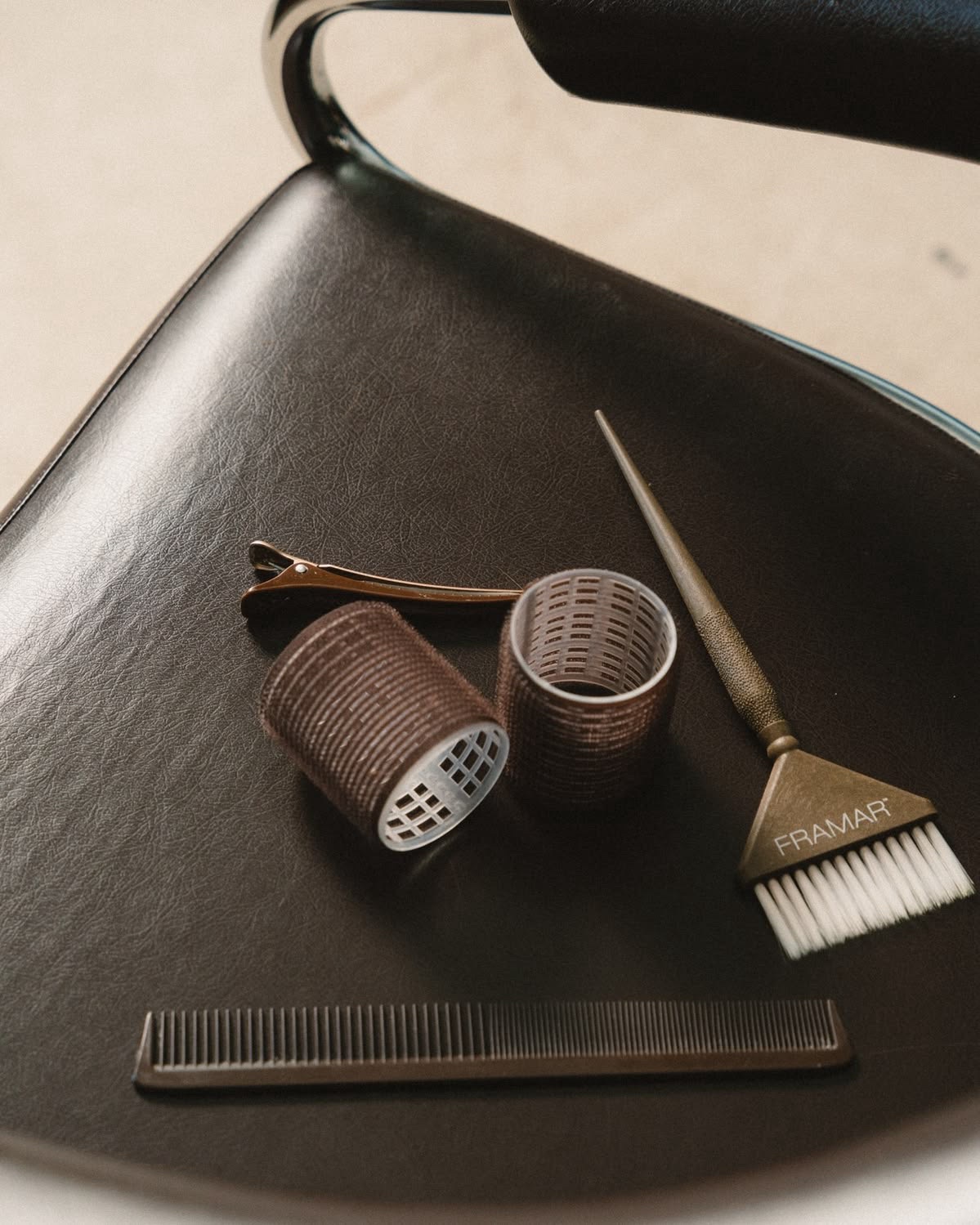 Salon chair with styling tools — rollers, tint brush and comb