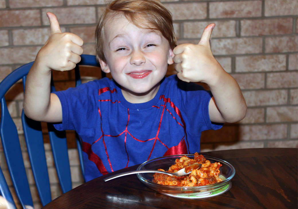 A real kid gives two enthusiastic thumbs up over his Maestro Meatball dinner