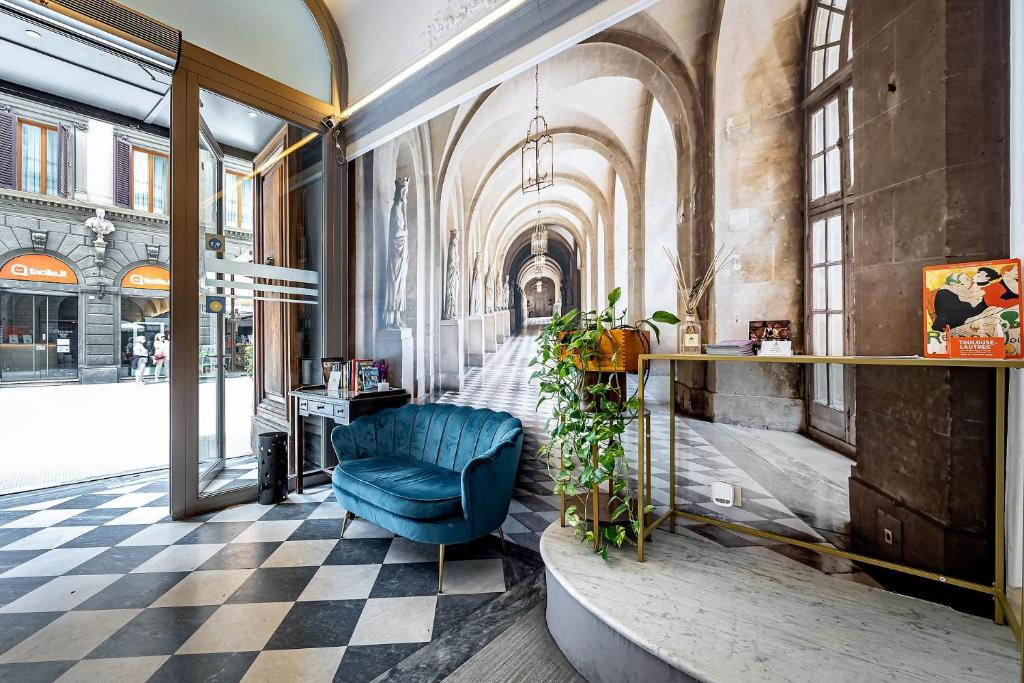 The boutique hotel lobby — checkered marble floor and a Florentine arcade mural